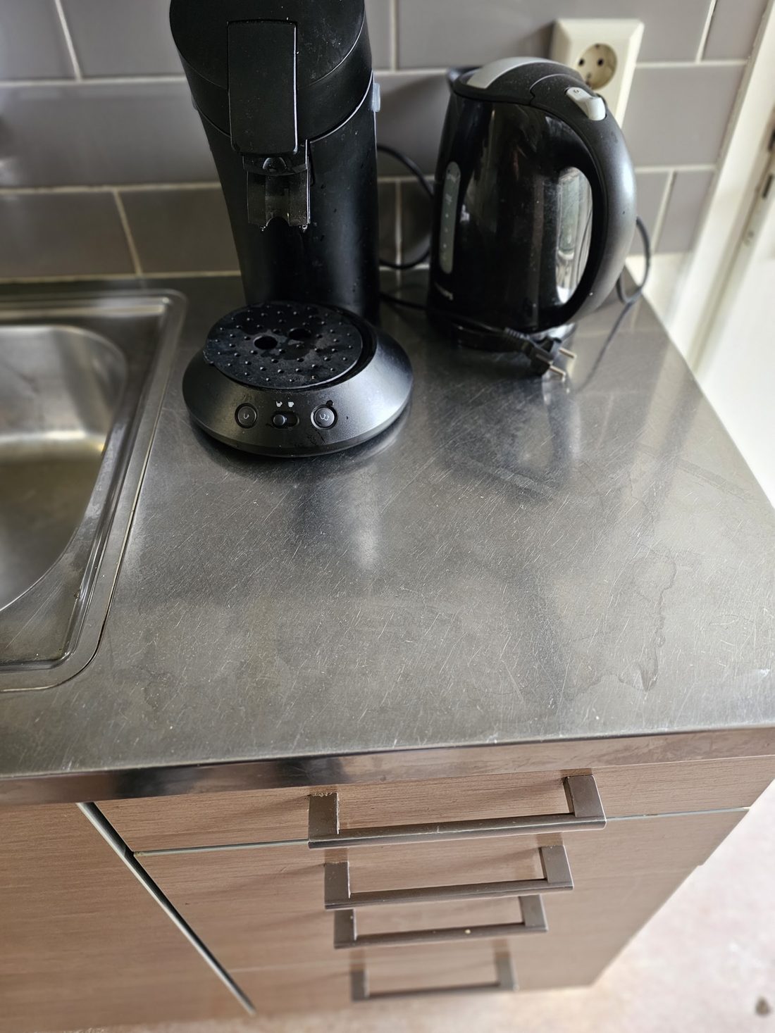 Dezelfde roestvrijstalen aanrecht met koffiezetapparaat en waterkoker, nu spotless